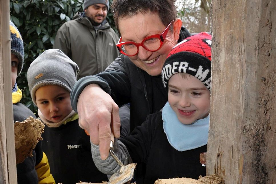 Bauunternehmerin Petra Mey-Wirtz erklärte den Kindern die Arbeitsweise mit Lehm. Foto: Reiner Züll
