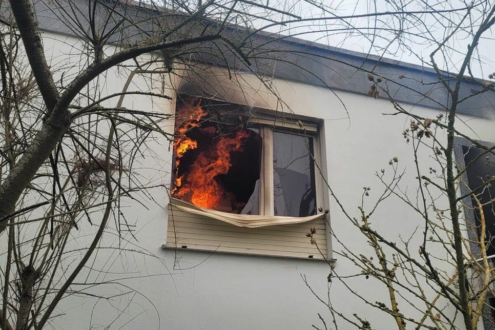 Das Foto zeigt ein Fenster des Bungalows. In dem Raum sind deutlich Flammen zu erkennen. Das Feuer im Bungalow hat sich nach ersten Erkenntnissen in der Küche entwickelt.