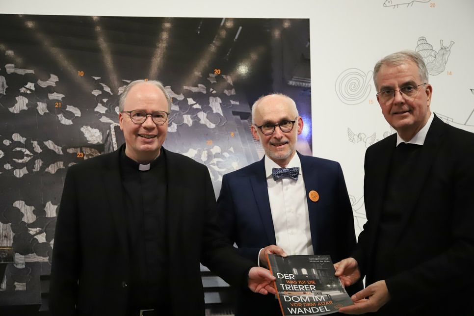 Bischof Dr. Stephan Ackermann, Museumsdirektor Markus Groß-Morgen und Dompropst Weihbischof Jörg Peters bei der Ausstellungseröffnung vor einem Bild der Altarinsel von oben.