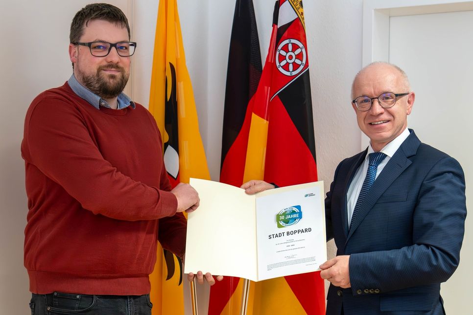 Boppards Bürgermeister Jörg Haseneier (rechts) und Klimaschutzmanager Dominik Nachtsheim mit der Urkunde für 30 Jahre Mitgliedschaft im Klima-Bündnis.