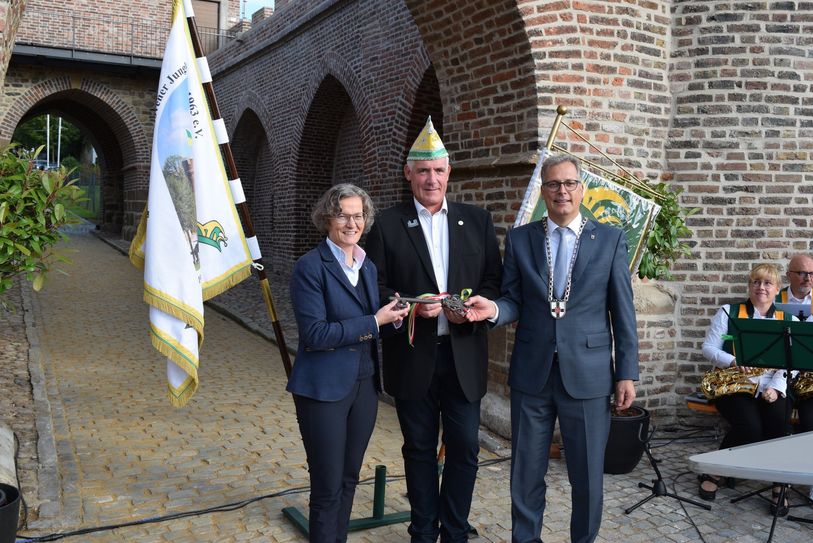 Gemeinsam mit Ministerin Ina Scharrenbach (li.) überreichte Zülpichs Bürgermeister Ulf Hürtgen (re.) den symbolischen Schlüssel für das Weiertor an Gerd Wallraf, den Präsidenten der Hovener Jungkarnevalisten.