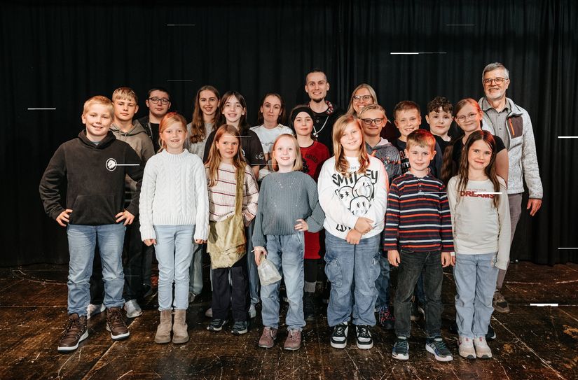 Eine Truppe aus Jung und Alt betritt die Bühne.