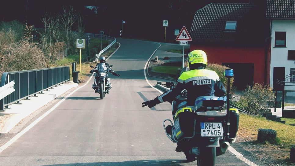 Motorradfahrer grüßen sich.