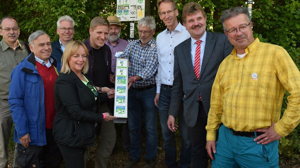 Gemeinsam brachten die Gäste und Ausrichter der Zentralveranstaltung zum Tag des Wanderns, darunter auch Manuel Andrack (re.) eine neue Markierung für mehrere Wanderwege in Bad Münstereifel an.  Foto: Scholl