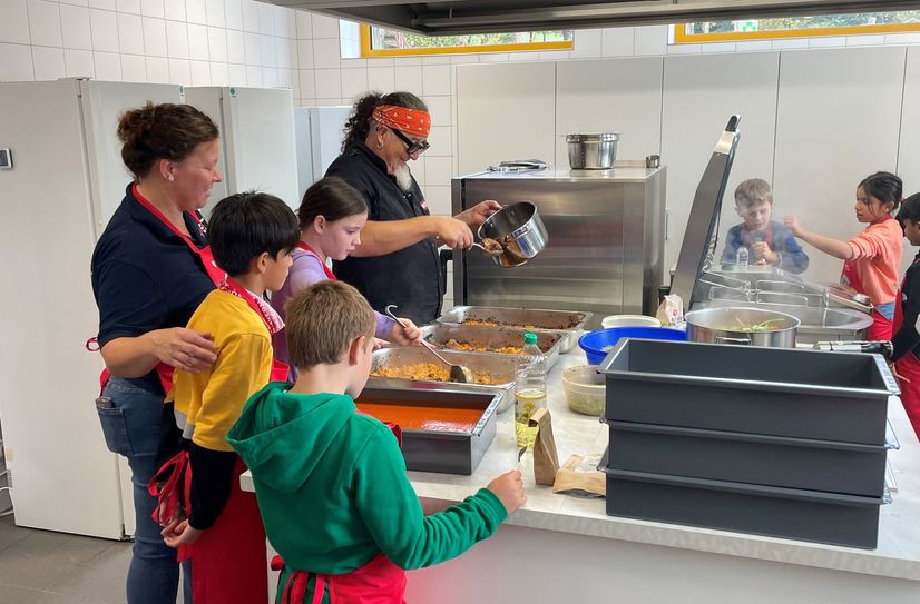 Gemeinsames Kochen mit Sternekoch Stefan Marquard in der Schulküche.