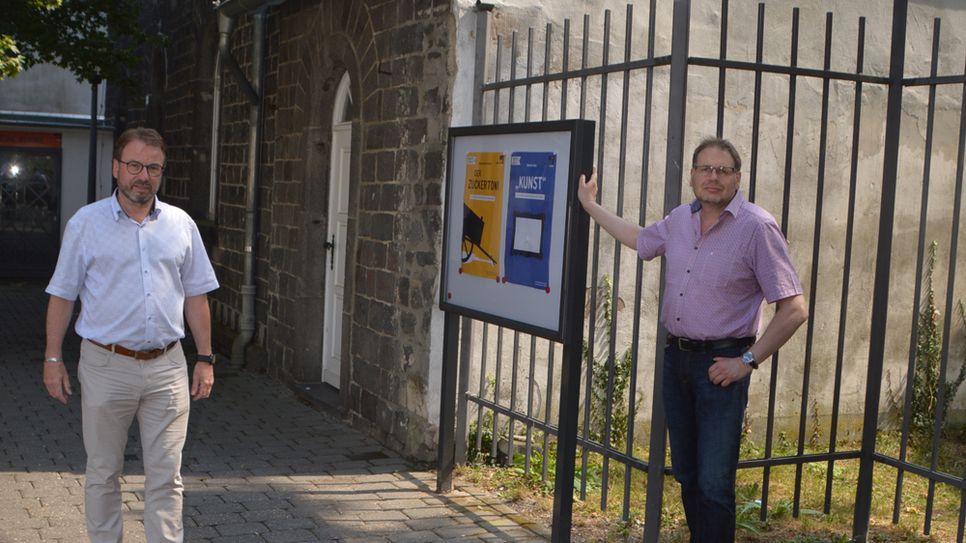 Oberbürgermeister Wolfgang Treis und der stellvertretende Vorsitzende Dr. Lutz Grunwald vor dem neu installierten Schaukasten der Burgfestspiele am Alten Arresthaus.