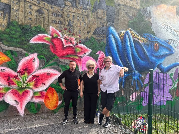 Für Birgit Salomon (Mitte) und Andreas Boerger (rechts) war es besonders wichtig, dass das Graffiti einen Bezug zu Moselkern aufweist, was Künstler Eugen »Famsy« Dorofeev (links) mit seinem farbenfrohen Kunstwerk bestens gelungen ist.