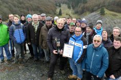 Sascha Irmiter aus Kaifenheim (mit Urkunde) inmitten seiner Feuerwehrkameraden, der durch VG-Bürgermeister Albert Jung, die Ortsbürgermeister von Laubach, Müllenbach und Leienkaul sowie den Wanderführer und Vereinsvorsitzenden Dieter Laux als 15.000. geführter Wanderer geehrt wurde.