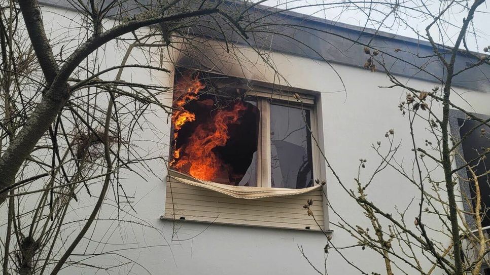Das Foto zeigt ein Fenster des Bungalows. In dem Raum sind deutlich Flammen zu erkennen. Das Feuer im Bungalow hat sich nach ersten Erkenntnissen in der Küche entwickelt.