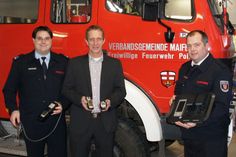 VG-Bürgermeister Maximilian Mumm übergibt dem Wehrleiter der Freiwilligen Feuerwehr Maifeld, Martin Wolff (rechts), und seinem Stellvertreter, Bernd Krechel (links), die neuen Geräte zur Messung der Kohlenmonoxid-Konzentration in der Luft.