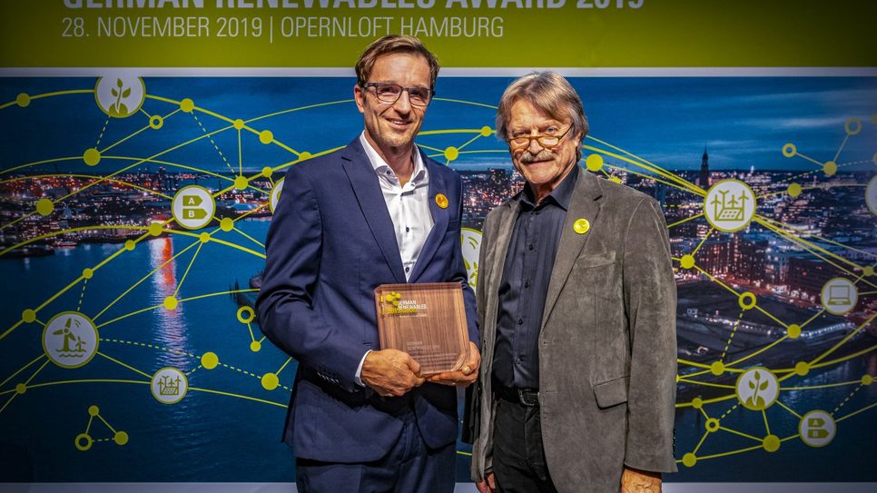 Der SWR-Fernsehjournalist Christian Hattesen erhält aus den Händen des Jurymitgliedes und Laudators Klaus Liedtke den „German Renewable Award 2019“. (Foto: Erneuerbare Energien Hamburg Clusteragentur GmbH)