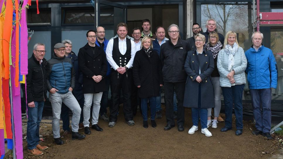 Bürgermeisterin Sabine Preiser-Marian  (8.v.li.) und Kindergarten-Leiterin Sabine Bordihn (2.v.re.) feierten gemeinsam mit Gästen und Handwerkern das Richtfest für den Erweiterungsbau. Foto: Scholl