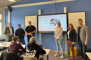 Von links: Landrat Volker Boch, Lehrer Tobias Fey, Schulleiter Manuel Hortian, Lehrerin Chiara Sohny, Fachbereichsleitung Linda Kemmer und Projektleiter Marco Barletta Puricelli in den Unterrichtsräumen der Puricelli Realschule plus Rheinböllen.