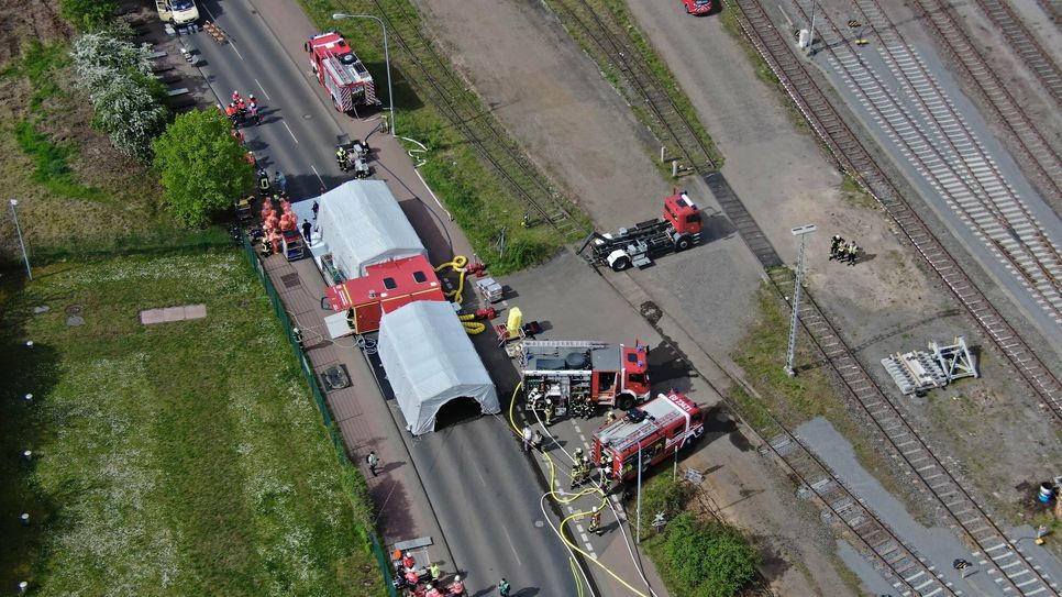 Zwei Feuerwehrleute bei Löscharbeiten auf dem Bahnhofsgelände.