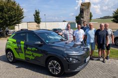 Ortsvorsteher Sven Weber (ganz links), Klimaschutzmanager Helge Lippert (3. von links) zusammen mit den vier Kümmerern präsentieren das Dorfauto am Bürgerhaus Hausen.