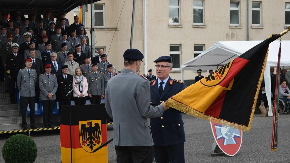 Generalleutnant Ludwig Leinhos übergibt die Fahne an Oberst Peter Webert. Foto: Scholl
