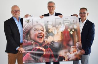 Von links: Wolfgang Nass, Erik Gregori und Ralf Nick präsentieren stolz den 20. Adventskalender des Lions Clubs Simmern-Hunsrück, der am Montag in den Verkauf geht.