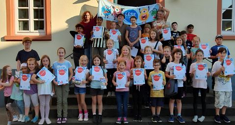 Die stolzen Teilnehmer des Lesesommers 2024 zusammen mit Sascha Gutzeit auf der Eingangstreppe der Alten Schule in Lutzerath.