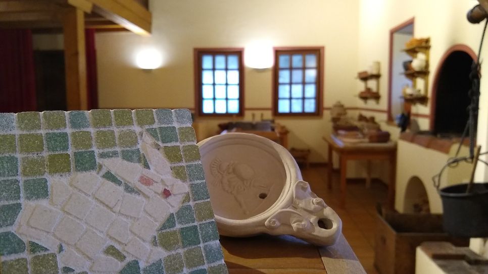 Besucher stellen in der Villa Borg Mosaike und Öllampen her. In der Römischen Küche werden gemeinsam verschiedene Speisen zubereitet und verkostet.