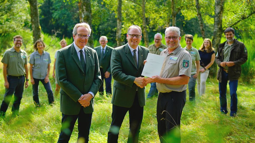 Mit dem Leitungsteam der Nationalparkverwaltung im Rücken erhält Michael Lammertz die Urkunde zur Ernennung als Leiter des Nationalparks Eifel aus den Händen von NRW-Landesforstchef Daniel Hartmann (Mitte) und Heinrich Barkmeyer, Vertreter der Leitung von Wald und Holz NRW.