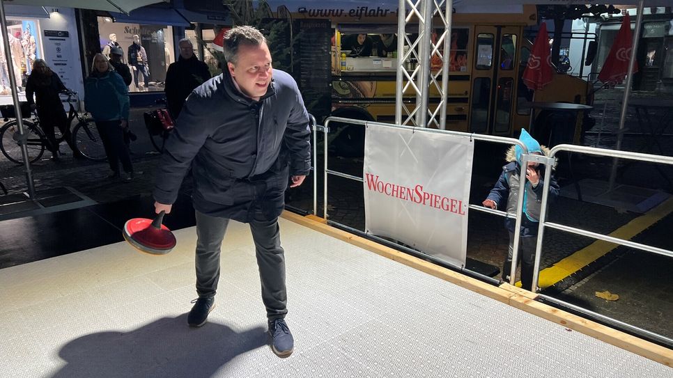 Bürgermeister Sacha Reichelt, testete die Eisstockbahn anlässlich der offiziellen Eröffnung.