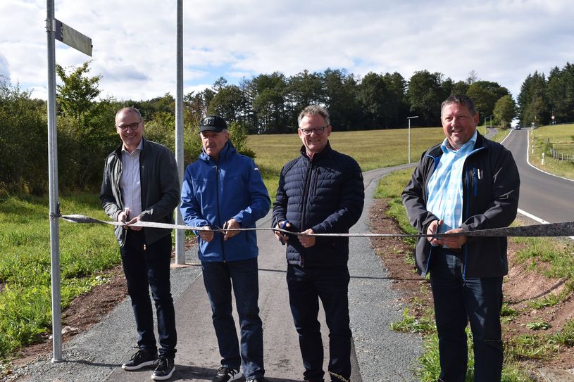 Von links nach rechts: Der neue Bürgermeister der Verbandsgemeinde Hermeskeil, Stefan Ding, sein Vorgänger Hartmut Heck, Landrat Stefan Metzdorf und Ortsbürgermeister Ulrich Frohn durchschneiden das Band anlässlich der feierlichen Einweihung des neuen "Schmille"-Weges.