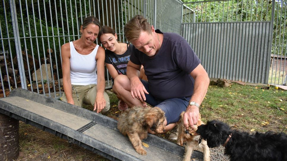 Bettina Anedda (l.) und ihre Tochter Finja haben die kleine Christa (1. v. l.) in ihre Herzen geschlossen. Bis sie in ihr neues Zuhause kommt, kümmert sich Claus-Peter Krah um den Welpen. Fotos: Wicher