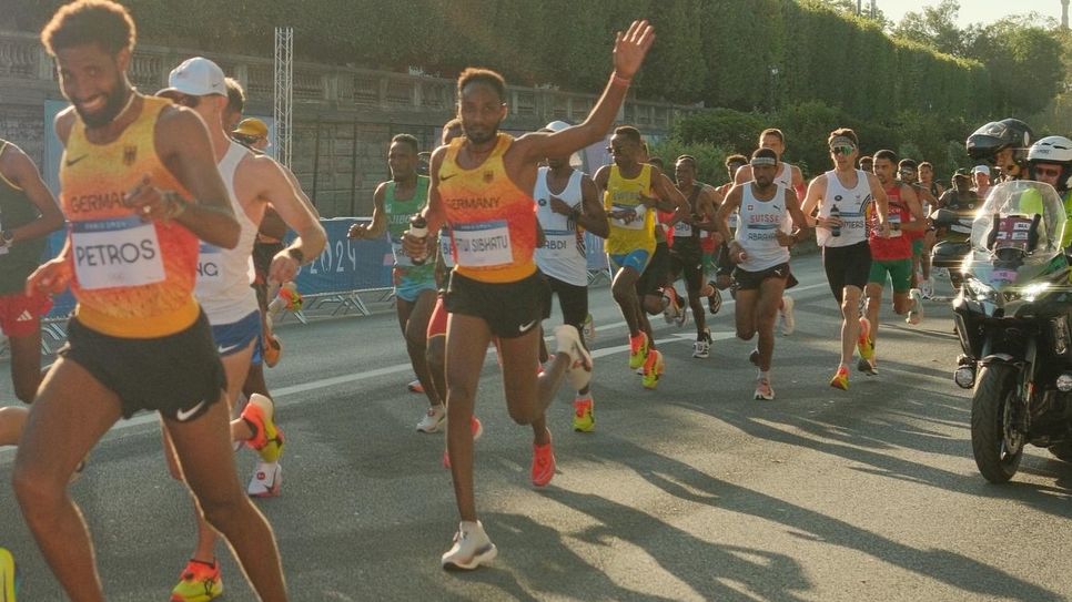 Samuel Fitwi am Samstag auf der Marathonstrecke in Paris, bei Kilometer 6: Er winkt seinen gut 100 Fans aus der Vulkaneifel zu, die eigens in Bussen zu seinem großen Lauf gefahren sind.